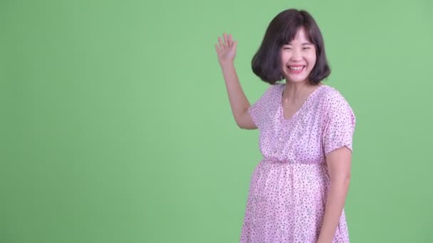 Szczęśliwy Azji ciąży kobieta pokazując dla w plecy — Wideo stockowe