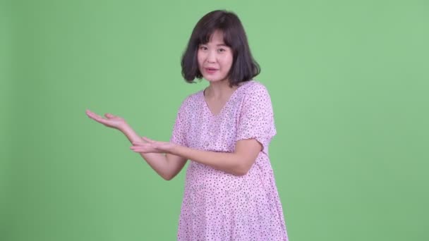 Mutlu Asyalı hamile kadın sunum yapıyor. — Stok video