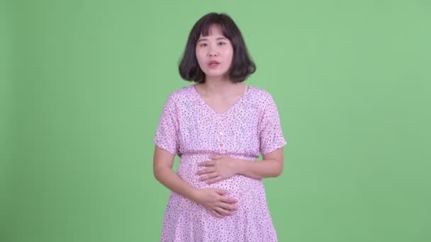 Счастливая беременная азиатка хлопает в ладоши — стоковое видео