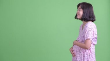 Gülümseyen Asyalı hamile kadının profili