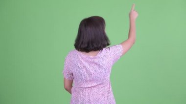 Asyalı hamile bir kadının parmak göstermesi.