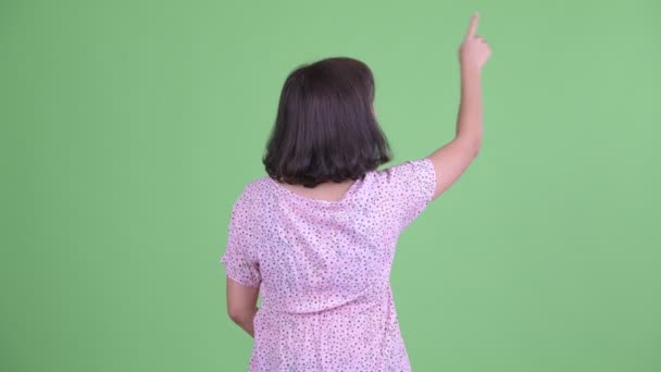 Vue arrière de la femme enceinte asiatique pointant du doigt — Video