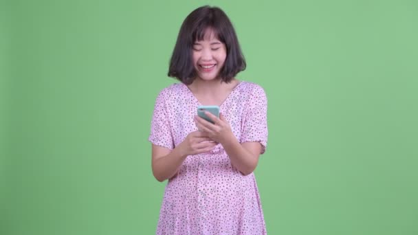 Boldog ázsiai terhes nő telefonál — Stock videók