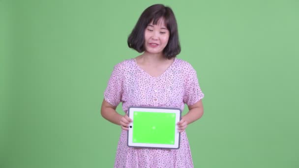Ευτυχισμένη Ασιάτισσα έγκυος γυναίκα μιλάει ενώ δείχνει ψηφιακή ταμπλέτα — Αρχείο Βίντεο