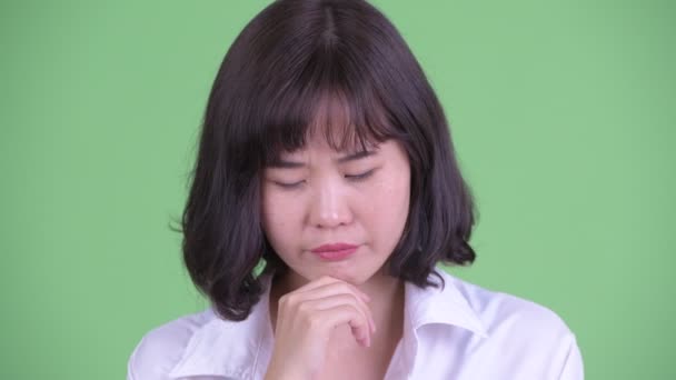 Tvář přízvučné asijské podnikatelka myšlení a při pohledu dolů — Stock video
