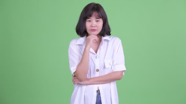 Estresada mujer de negocios asiática pensando y mirando hacia abajo — Vídeo de stock