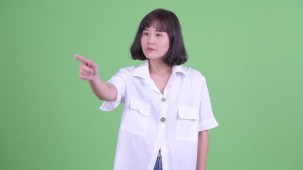 Щаслива азіатська бізнесменка, що вказує пальцем і направляє — стокове відео