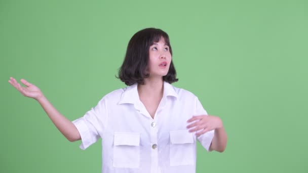 Happy beautiful Asian businesswoman catching something — Stock Video