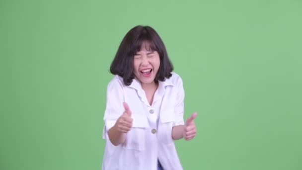 Щаслива азіатська бізнесменка, яка підносить пальці вгору і виглядає схвильованою. — стокове відео