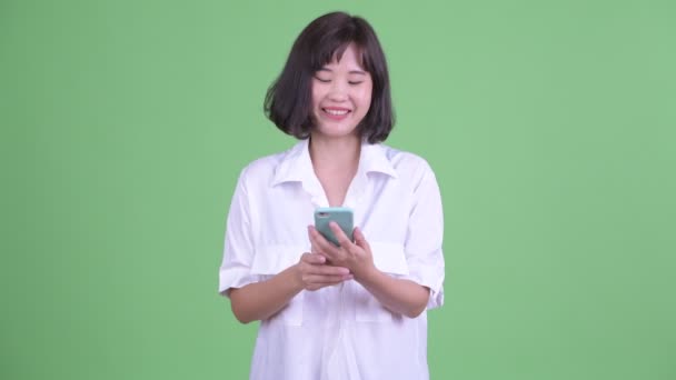 Telefon kullanırken düşünerek mutlu güzel Asya iş kadını — Stok video