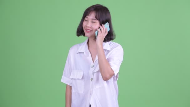 Счастливая красивая азиатская деловая женщина разговаривает по телефону — стоковое видео