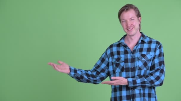 Boldog fiatal jóképű csípő ember mutat valami — Stock videók