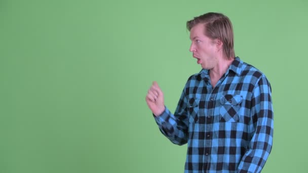 Gestresste jonge hipster man raakt iets aan en kijkt walgelijk — Stockvideo