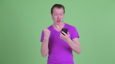 Telefon kullanıyorsanız ve iyi haber mutlu genç yakışıklı adam