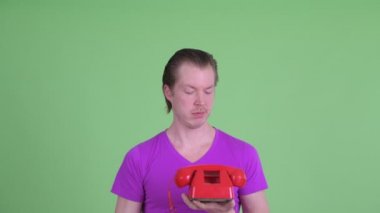 Stresli genç adamın yüzü eski telefon kullanıyor.