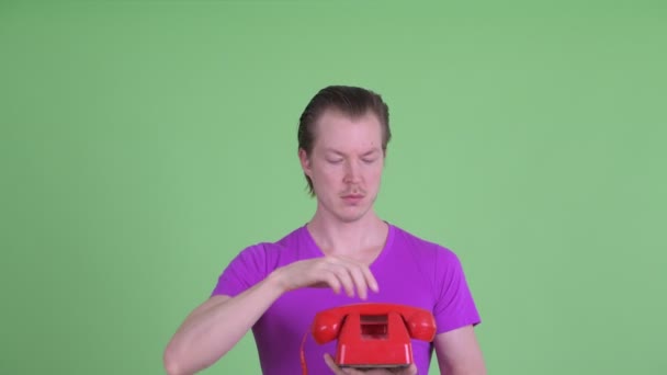 Обличчя молодого красивого чоловіка, який використовує старий телефон — стокове відео