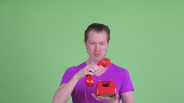 Face of angry young man shouting and screaming at old telephone — Stock Video