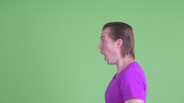 Крупним планом вид з профілю смішний молодий чоловік виглядає шокованим — стокове відео