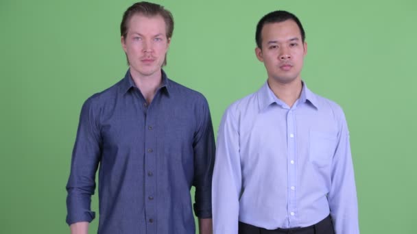Två stressade multietniska affärsmän ger tummen ner tillsammans — Stockvideo