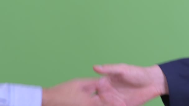 Két többnemzetiségű üzletember keze, akik kezet ráznak. — Stock videók