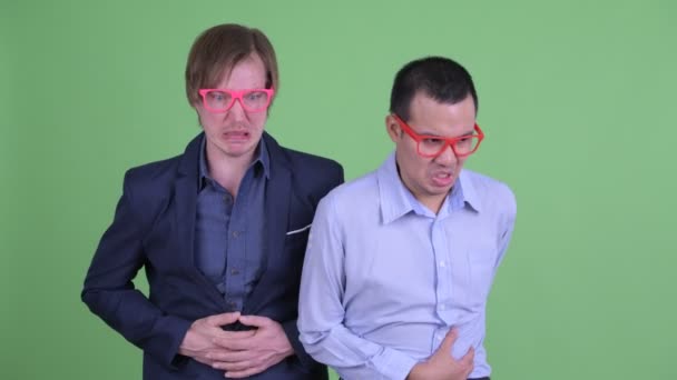 Two funny multi ethnic businessmen having stomachache together — Stock videók