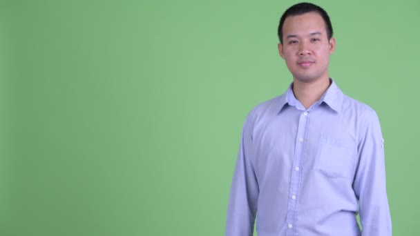 Счастливый азиатский бизнесмен показывает пальцем и показывает что-то — стоковое видео