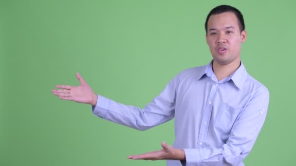 행복 한 아시아 사업가가 무언가를보여 주면서 이야기하는 모습 — 비디오