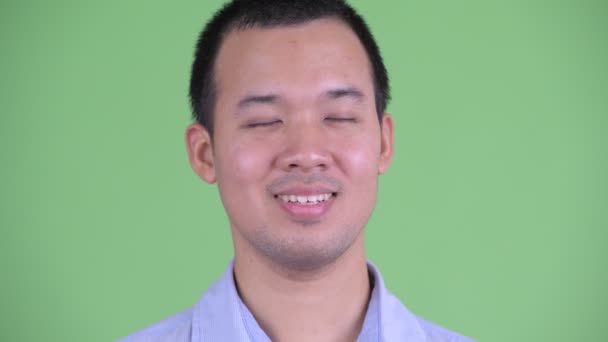 目を閉じてリラックスした幸せなアジアのビジネスマンの顔 — ストック動画