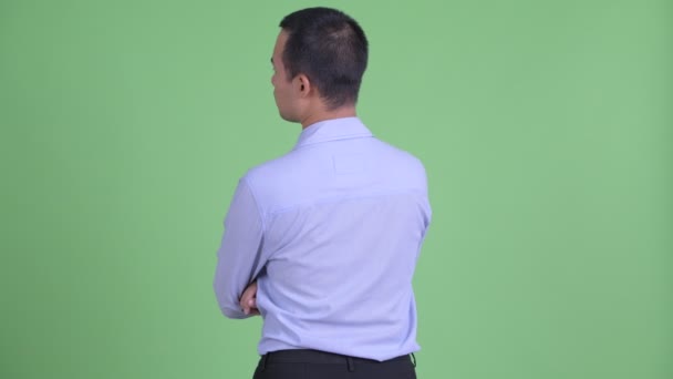 Visão traseira do empresário asiático pensando e olhando ao redor — Vídeo de Stock