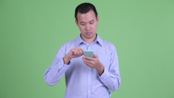 Glad asiatisk affärsman med telefon — Stockvideo