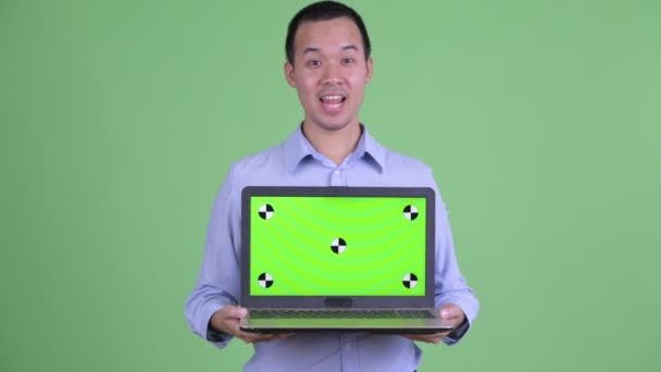 Feliz asiático hombre de negocios hablando mientras muestra portátil — Vídeos de Stock