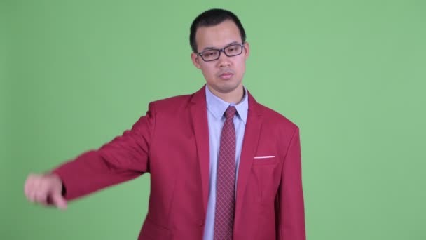 Triste uomo d'affari asiatico con occhiali dando pollici verso il basso — Video Stock