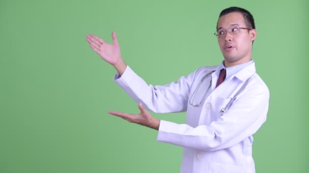Ευτυχισμένος Ασιάτης γιατρός που χτυπάει δάχτυλα και μιλάει. — Αρχείο Βίντεο