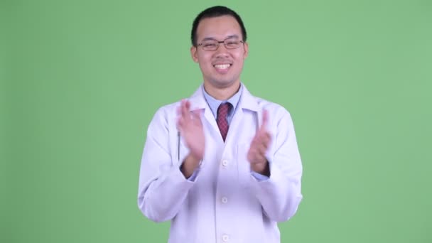 Happy Asian man doctor with eyeglasses clapping hands — Stock Video