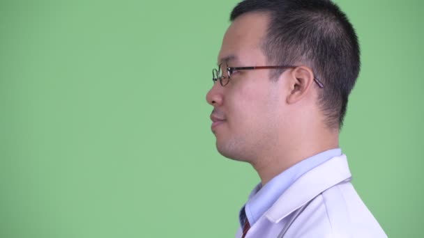 Primer plano perfil vista de feliz asiático hombre médico con gafas sonriendo — Vídeos de Stock