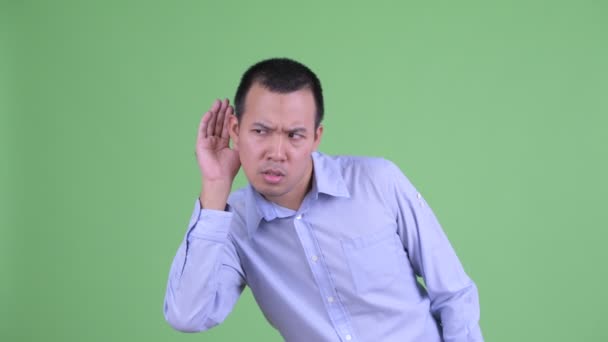 Stressed Asian businessman listening and looking shocked — Stock Video