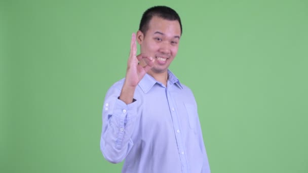 Зйомки щасливого азіатського бізнесмена з крутим знаком — стокове відео