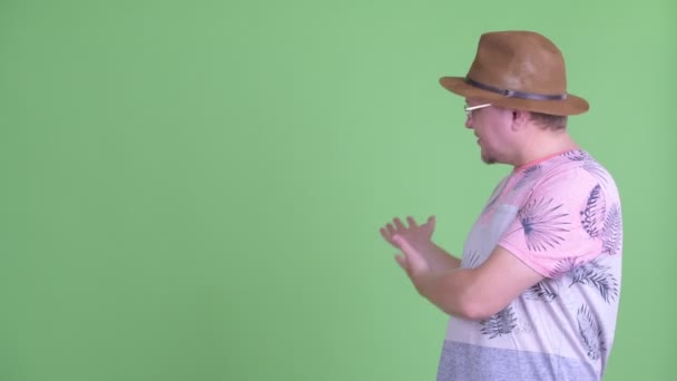 Šťastný nadváha vousatý turista ukazující se vzadu — Stock video