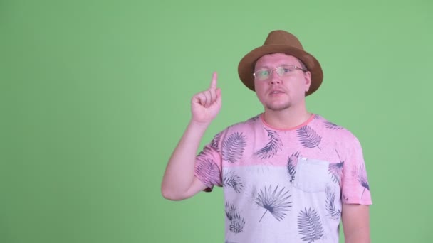 Feliz hombre turista barbudo con sobrepeso hablando mientras señala hacia arriba — Vídeos de Stock