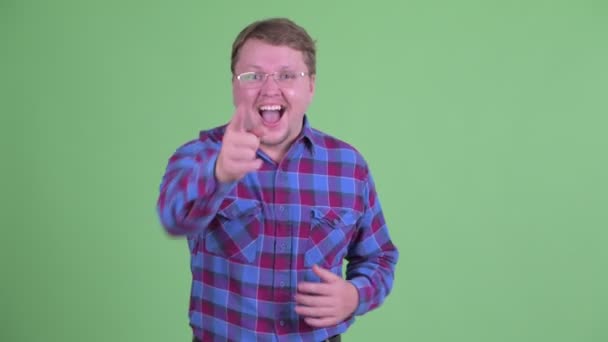 Ευτυχισμένος υπέρβαρος γενειοφόρος hipster άνθρωπος γελώντας και δείχνοντας κάμερα — Αρχείο Βίντεο