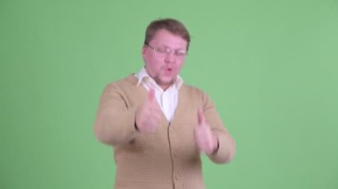 Mutlu şişman sakallı adam başparmağını kaldırıyor ve heyecanlı görünüyor.