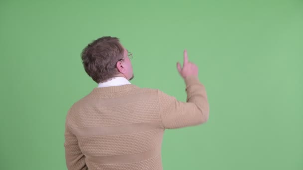Achteraanzicht van de man met de baard die met de vinger wijst naar overgewicht en richting geeft — Stockvideo