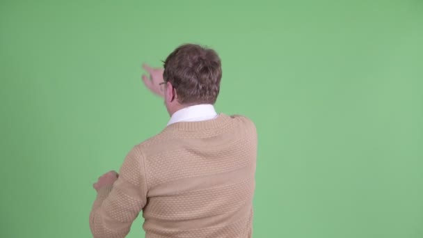 Zadní pohled na nadváhu vousatého muže dotýkajícího se něčeho — Stock video