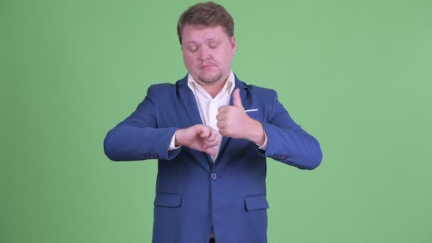 Confused overweight bearded businessman choosing between thumbs up and thumbs down — Stock Video