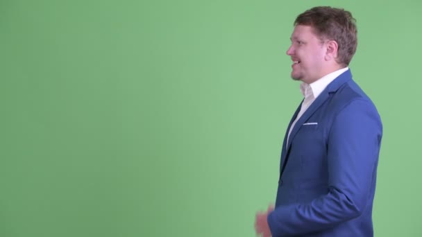 Vue du profil de l'homme d'affaires barbu heureux en surpoids souriant et riant — Video