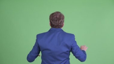 Şişman sakallı iş adamının bir şeye dokunuşunun arka görüntüsü.