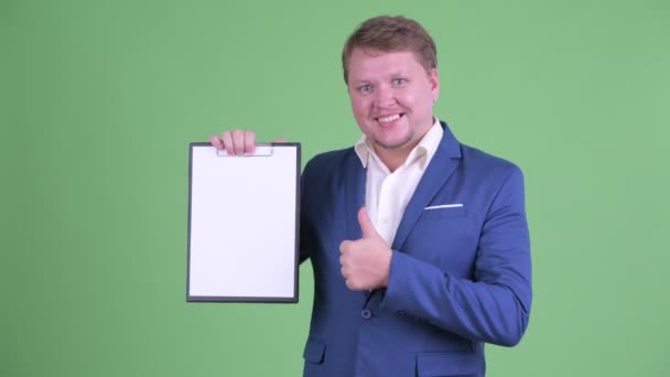 Šťastný nadváha vousatý podnikatel ukazující schránku a dávat palce nahoru — Stock video