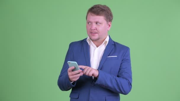 Šťastný nadváha vousatý podnikatel mluvit při použití telefonu — Stock video