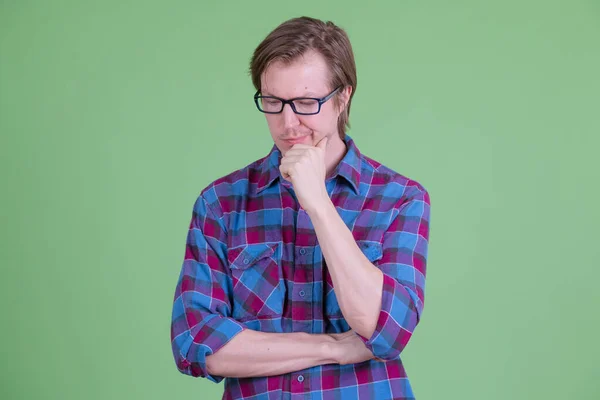 Stressé jeune homme hipster avec des lunettes de vue penser et regarder vers le bas — Photo