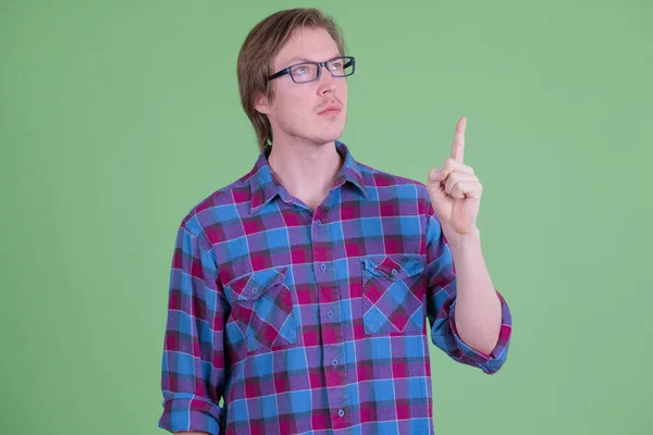 Mladý pohledný hipster muž přemýšlí a ukazuje nahoru — Stock fotografie